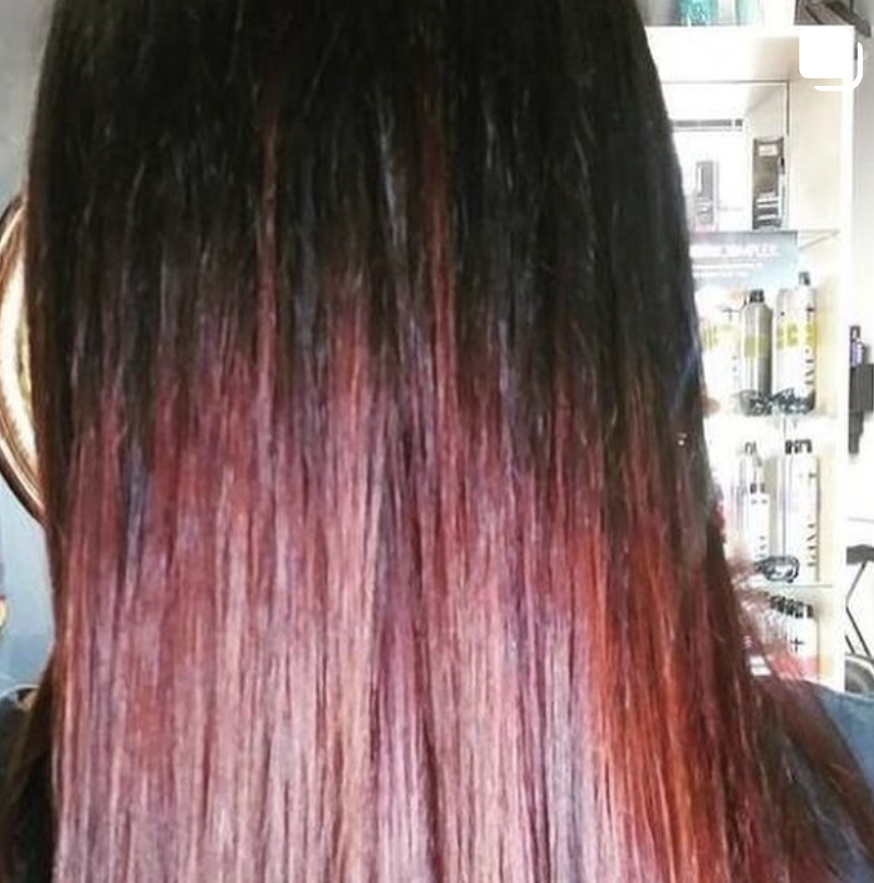 A close up of a woman 's hair with red highlights