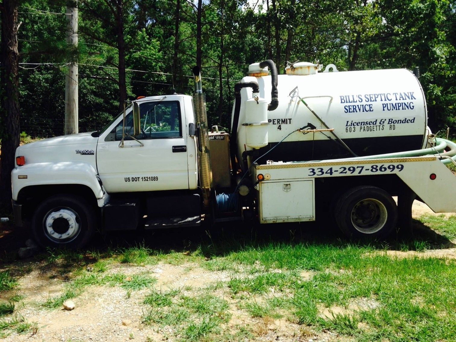 A white vacuum truck is parked in a parking lot. A white vacuum truck is parked in a parking lot.