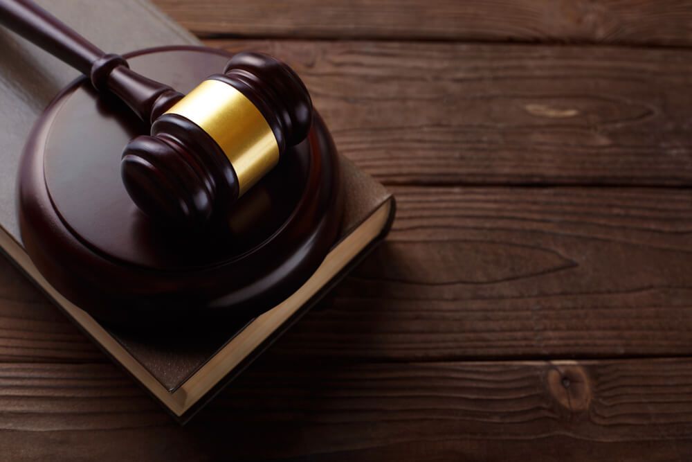 Judge's Utilized Antique Book and Wooden Mallet on Table — Solicitor in Wagga Wagga