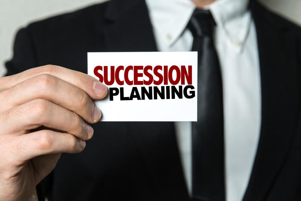 Suited Man Holds 'Succession Planning' Card — Solicitor in Wagga Wagga