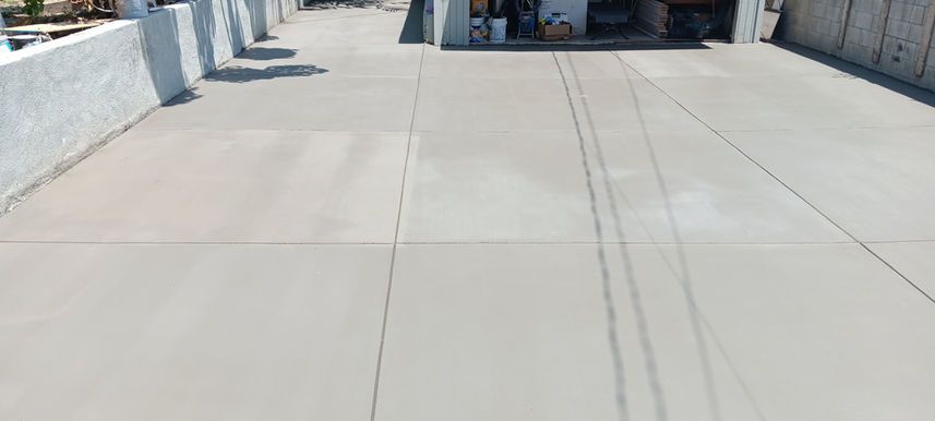 Empty concrete rooftop walkway with white walls and shadows