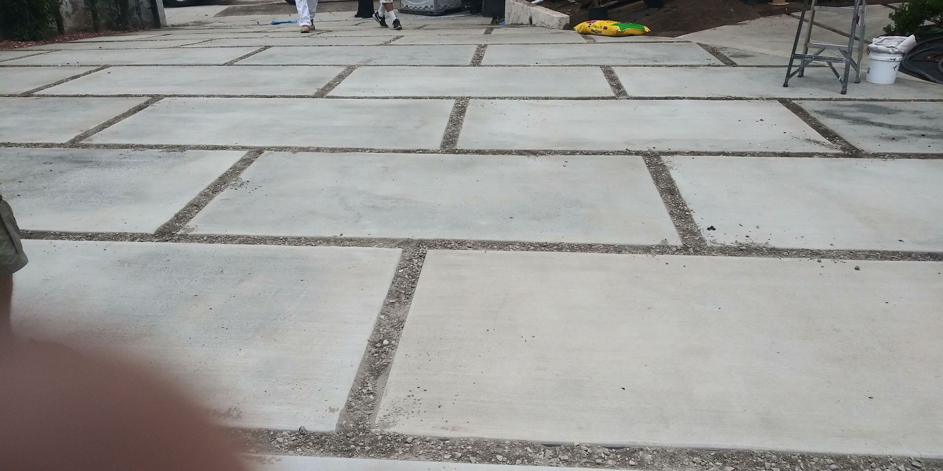 Stone-paved walkway with rectangular slabs and gravel joints, viewed from ground level.