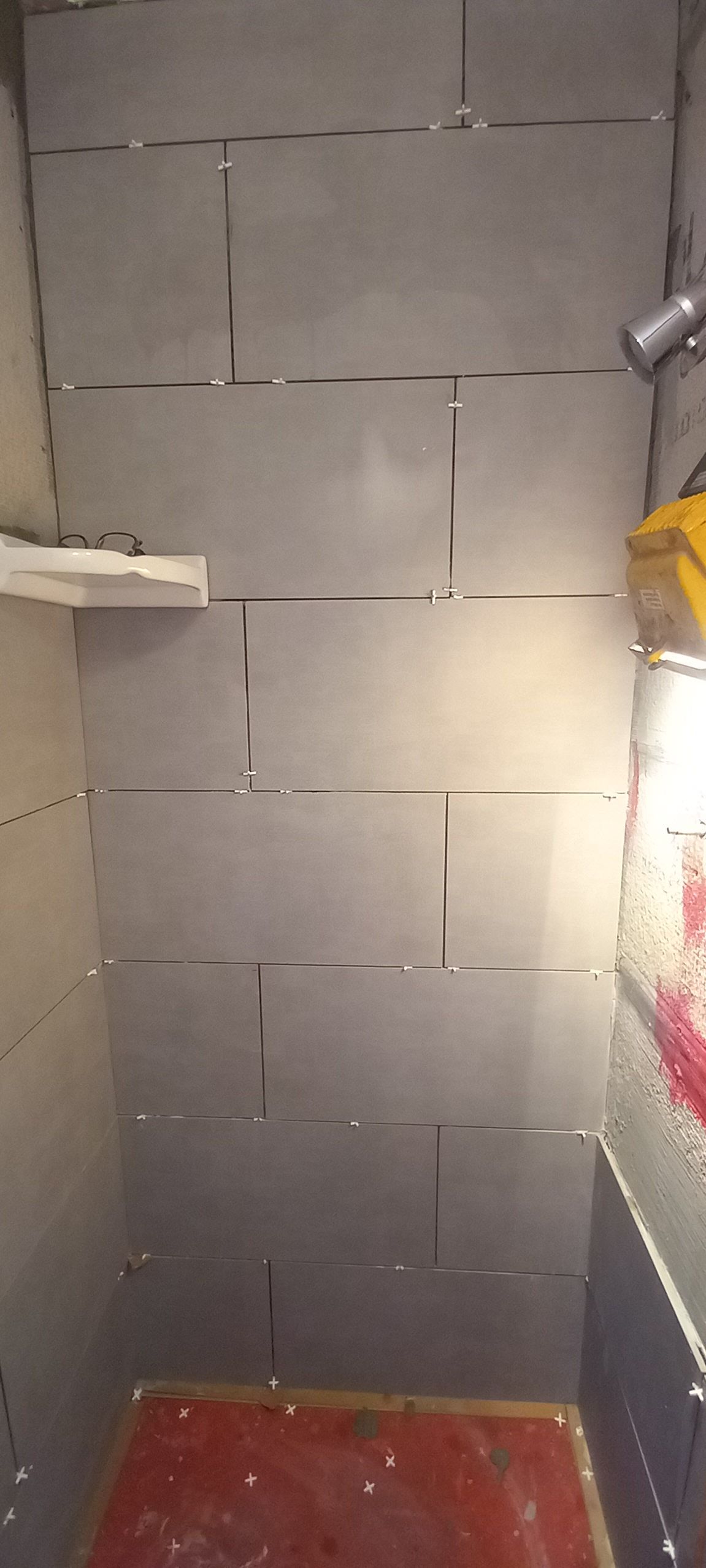 Narrow unfinished hallway with stacked gray cinder blocks and a red floor edge