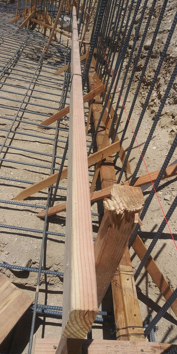 Damaged wooden beam and fallen roof trusses under a corrugated metal roof