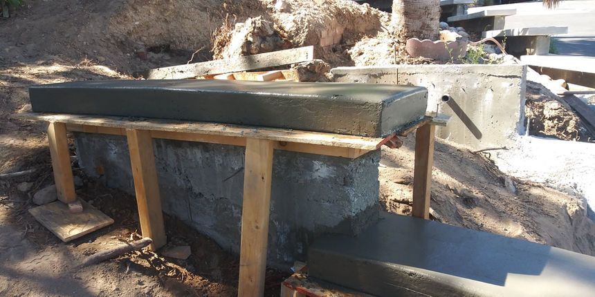 Outdoor wooden and concrete water trough beside a rocky hillside