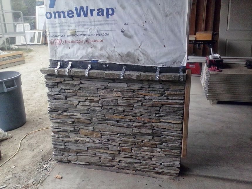 Wrapped stack of stone veneer panels on a pallet in a warehouse or loading area