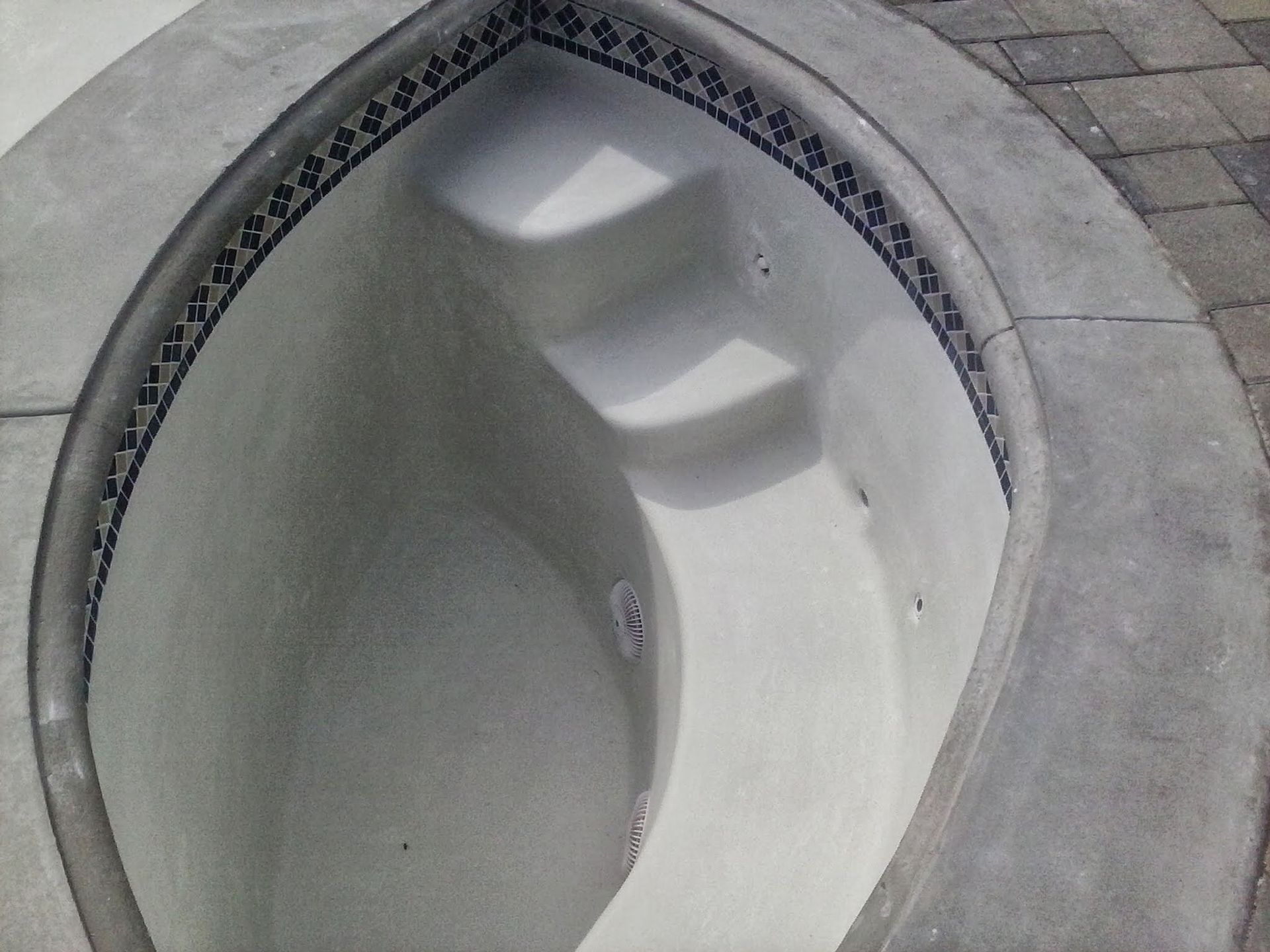 Oval white porcelain sink with three built-in faucet openings in a gray countertop