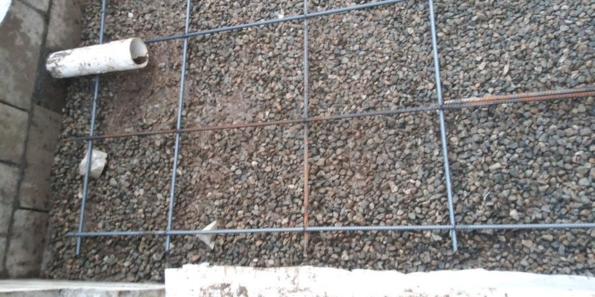 Concrete wall under construction with rebar grid and gravel-filled formwork