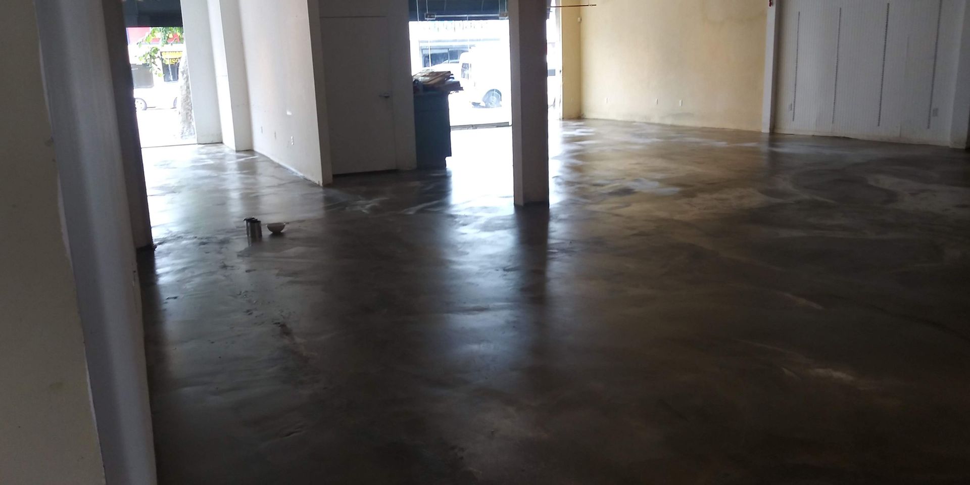 Empty warehouse interior with concrete floor and open doorway to daylight