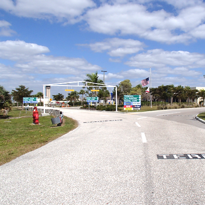 Entrance to an airport with signage, a US flag, and a security checkpoint.