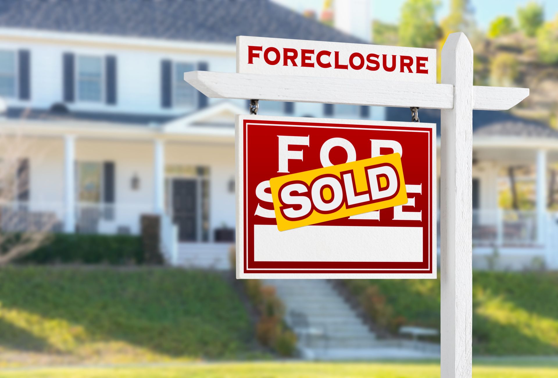 A house behind a white real estate sign that says