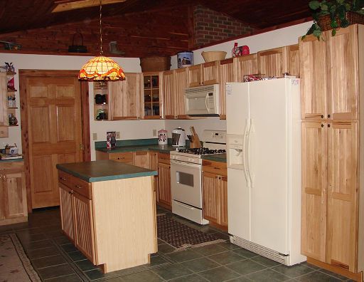 A kitchen with wooden cabinets and a white refrigerator