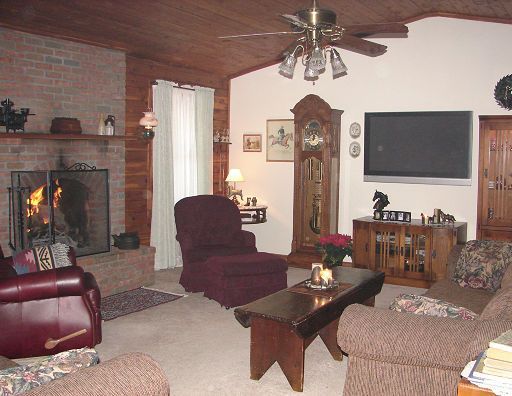A living room with a fireplace and a flat screen tv