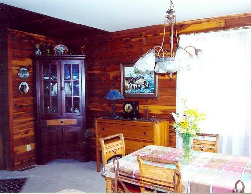 A dining room in a log cabin with a table and chairs