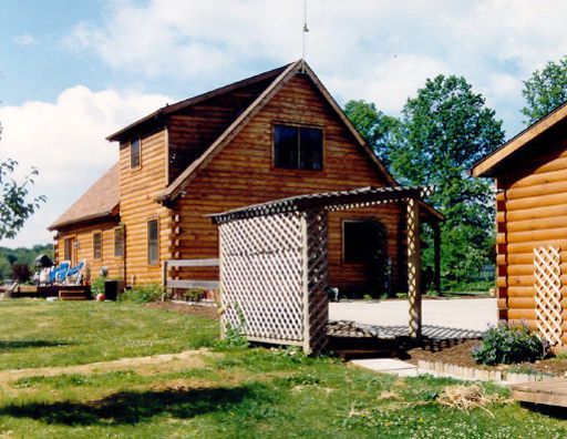 A wooden house with a shed in front of it