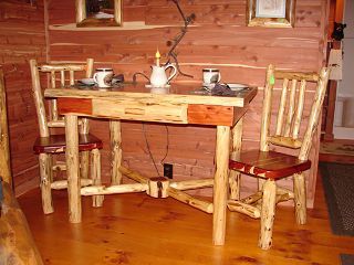 A wooden table and chairs in a room with a wooden floor.