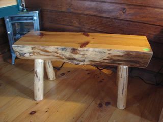 A wooden bench is sitting on a wooden floor in a room.