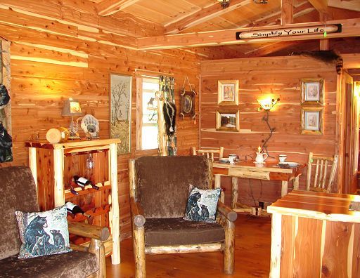 A living room in a log cabin with a table and chairs
