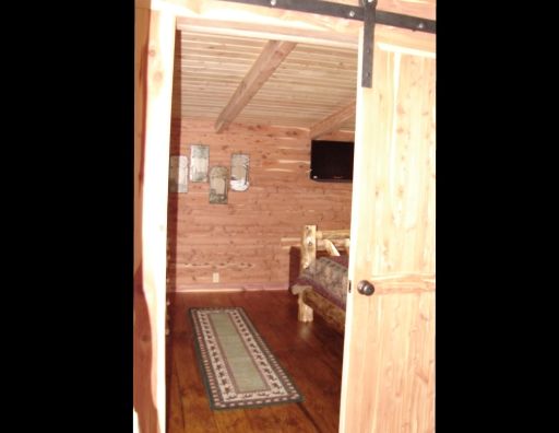 A bedroom in a log cabin with a sliding barn door