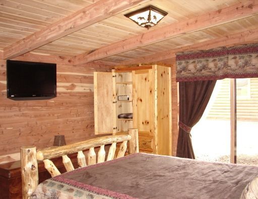 A bedroom with a large bed and a flat screen tv