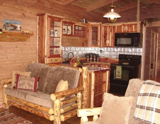 A living room with a couch and chairs and a kitchen