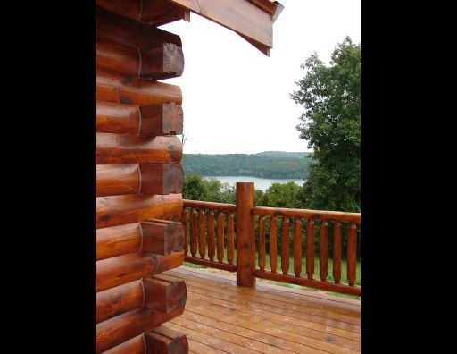 A log cabin with a deck overlooking a lake