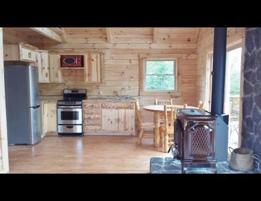A kitchen in a log cabin with a wood stove