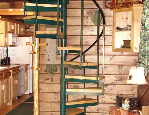 A kitchen with a spiral staircase leading up to the second floor