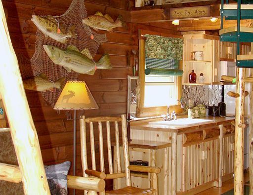 A kitchen in a log cabin with fish hanging on the wall