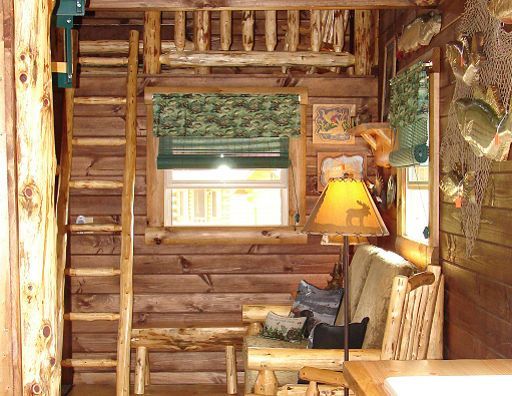 A wooden cabin with a ladder leading up to the second floor