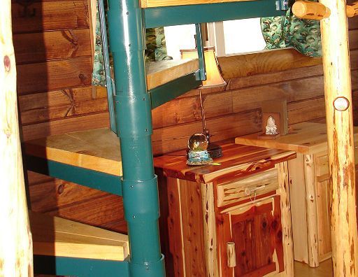 A wooden spiral staircase in a log cabin