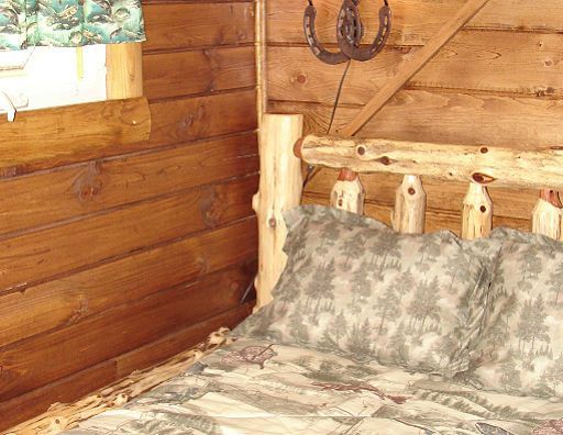 A bed with a horseshoe on the wall behind it