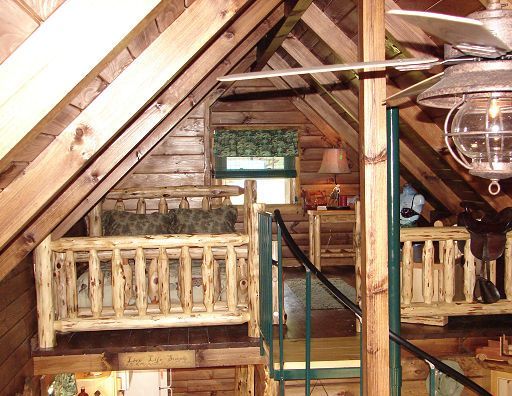 A wooden cabin with a staircase and a ceiling fan