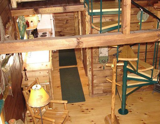 A wooden cabin with a spiral staircase leading up to the second floor