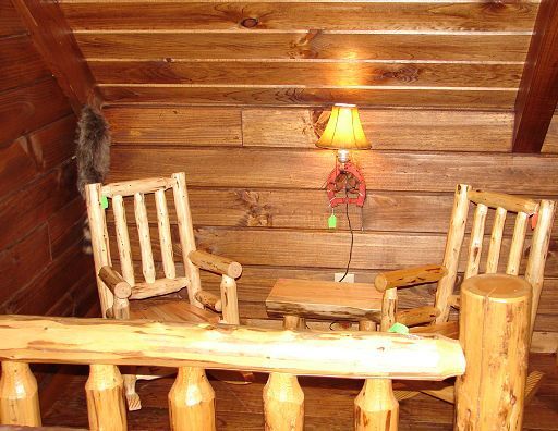 A wooden room with two rocking chairs and a table