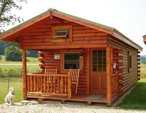 A small log cabin with a rocking chair on the porch