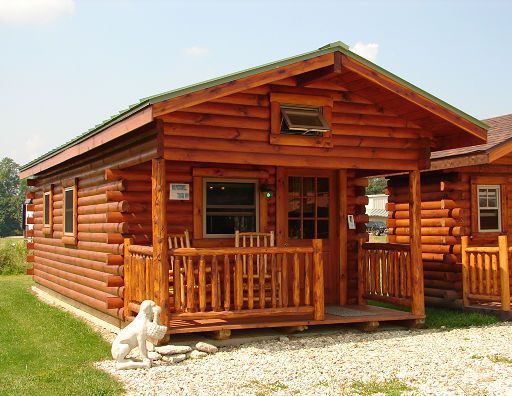 A small log cabin with a dog statue in front of it