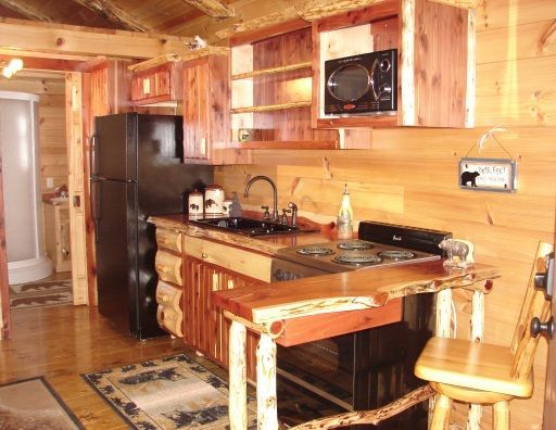 A kitchen with a stove , refrigerator , sink and microwave.