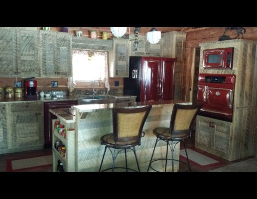 A kitchen with a red refrigerator and a microwave
