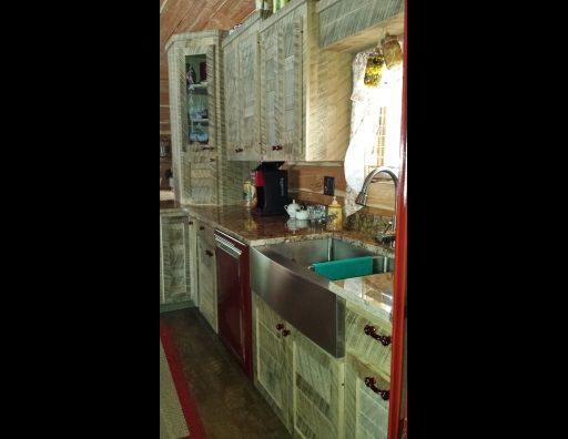 A kitchen with a sink , cabinets , and a window.
