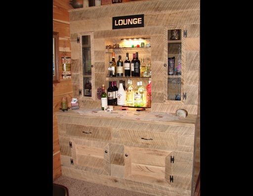 A wooden bar with bottles of liquor and a sign that says lounge