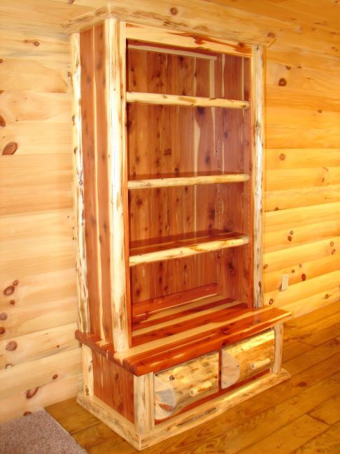 A wooden bookcase with shelves and drawers in a log cabin