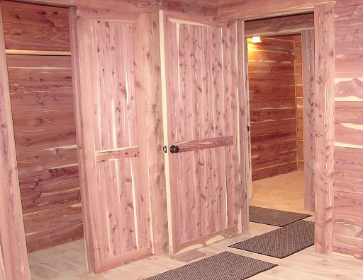 A hallway in a log cabin with wooden doors