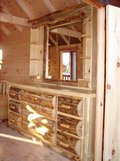 A wooden dresser with drawers and a mirror in a room.