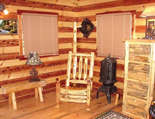 A log cabin with a rocking chair and a wood stove