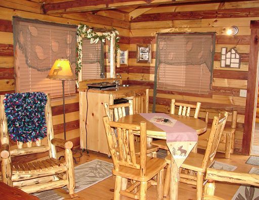 A dining room in a log cabin with a table and chairs