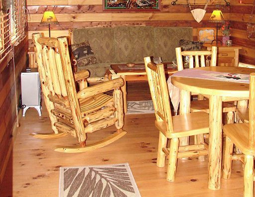A living room with a rocking chair and a table