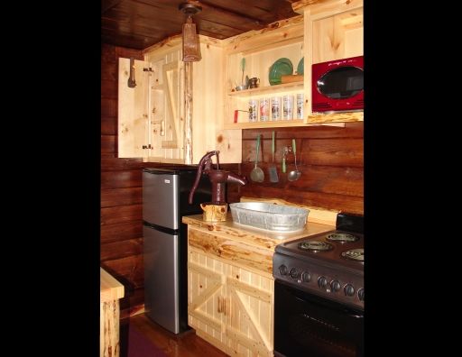 A kitchen with a stove , refrigerator , sink and microwave.