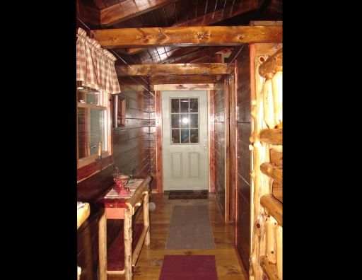 A hallway in a log cabin with a white door
