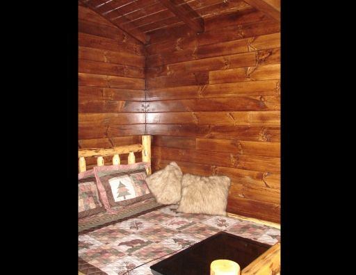 A wooden cabin with a bed and a coffee table.